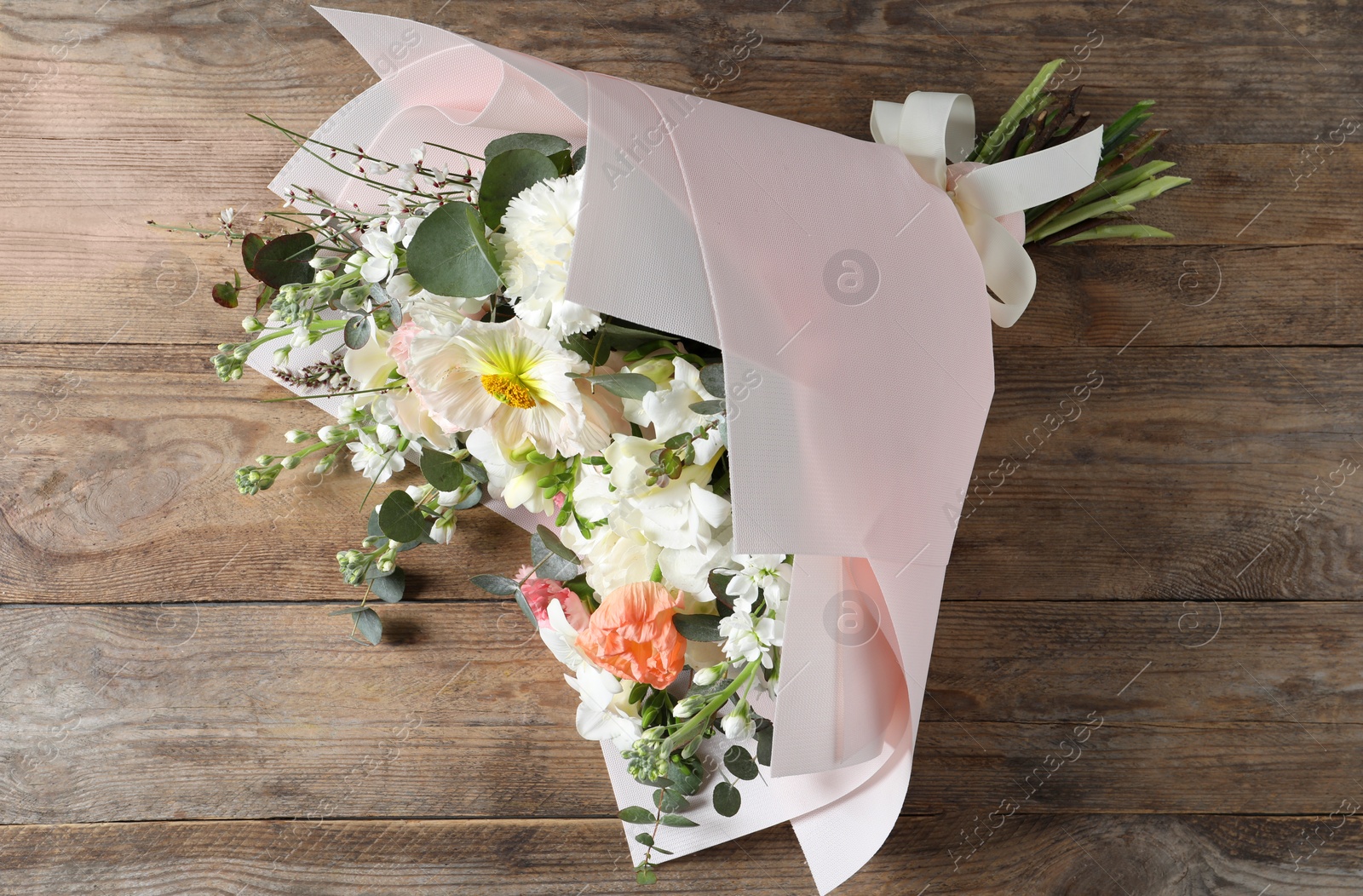 Photo of Bouquet of beautiful flowers on wooden table, top view