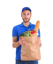 Photo of Delivery man holding paper bag with food products on white background