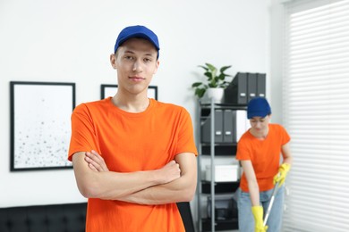 Portrait of cleaning service worker in office, selective focus