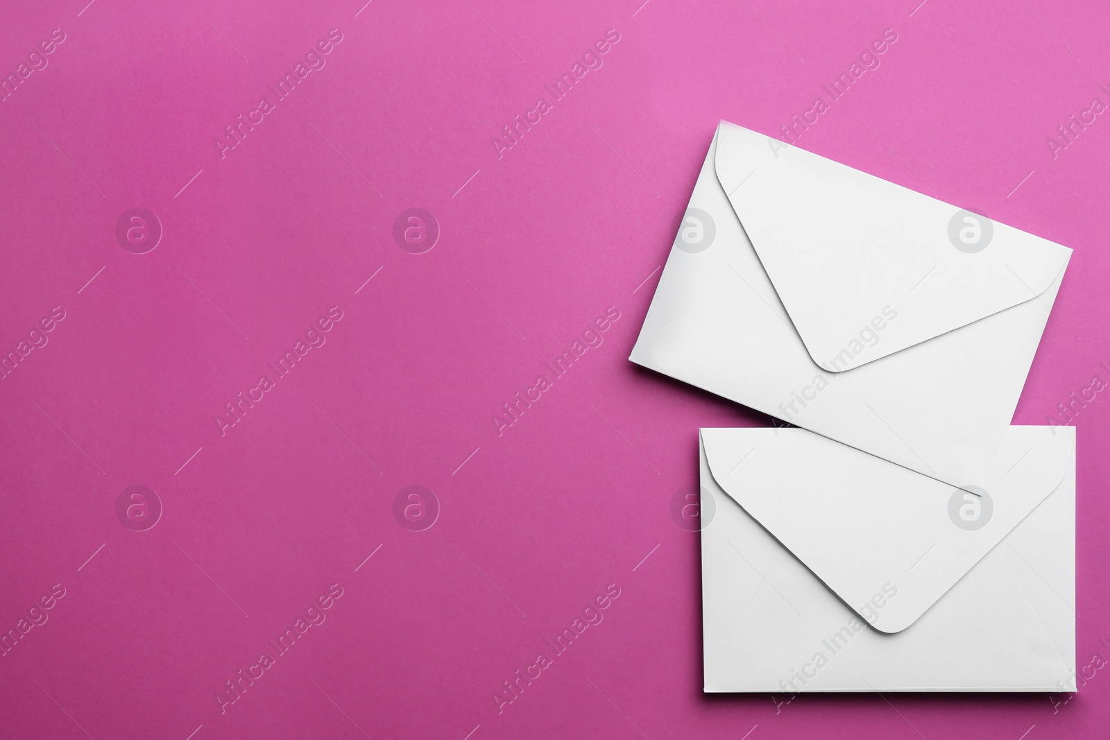 Photo of White paper envelopes on purple background, flat lay. Space for text