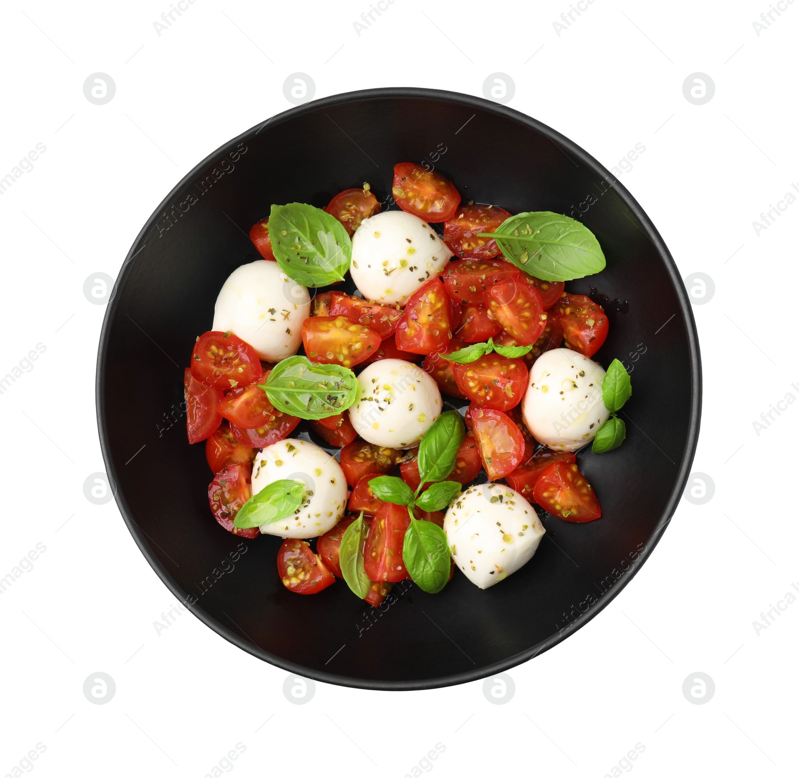 Photo of Bowl of tasty salad Caprese with tomatoes, mozzarella balls and basil isolated on white, top view