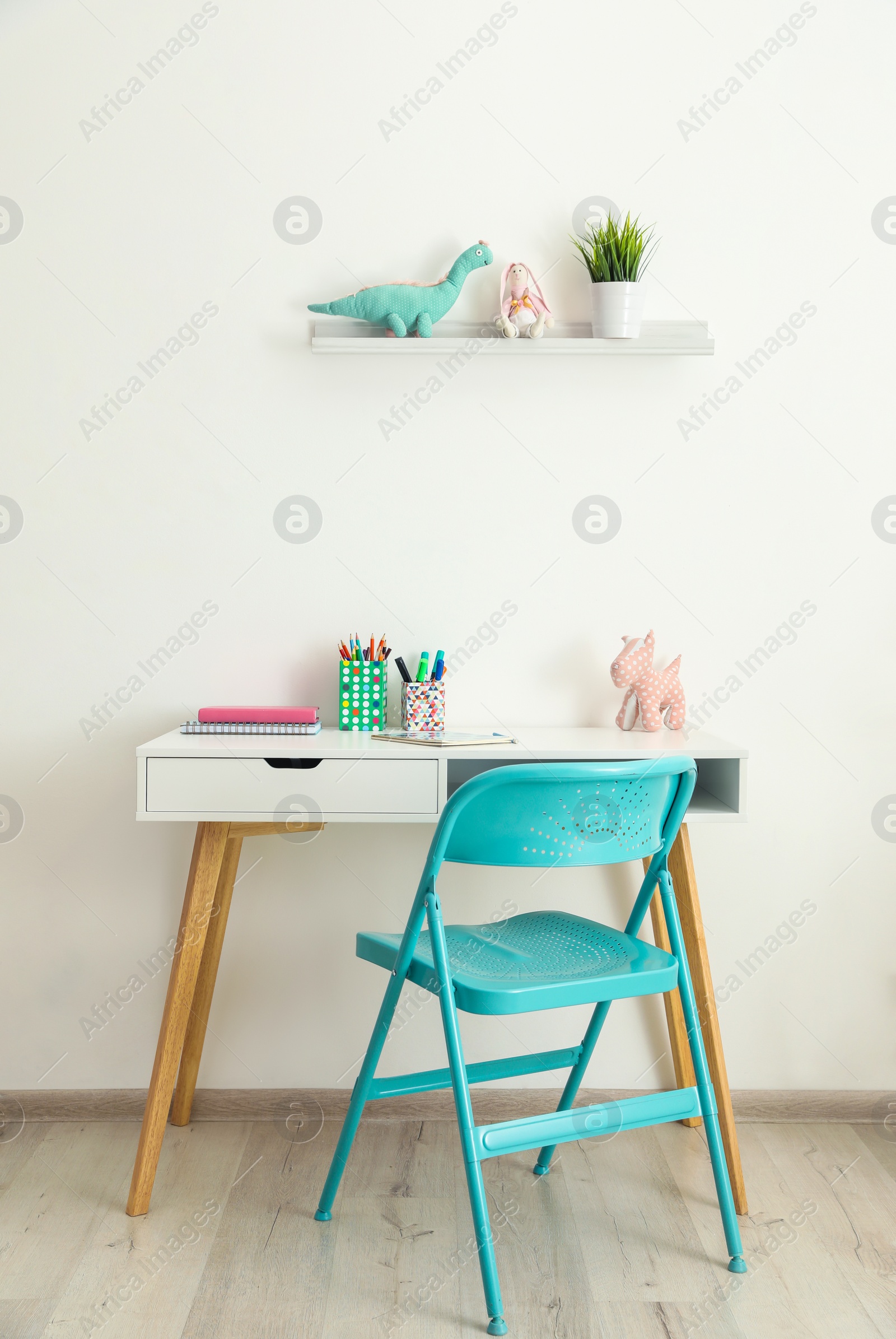 Photo of Table with chair near white wall in child room