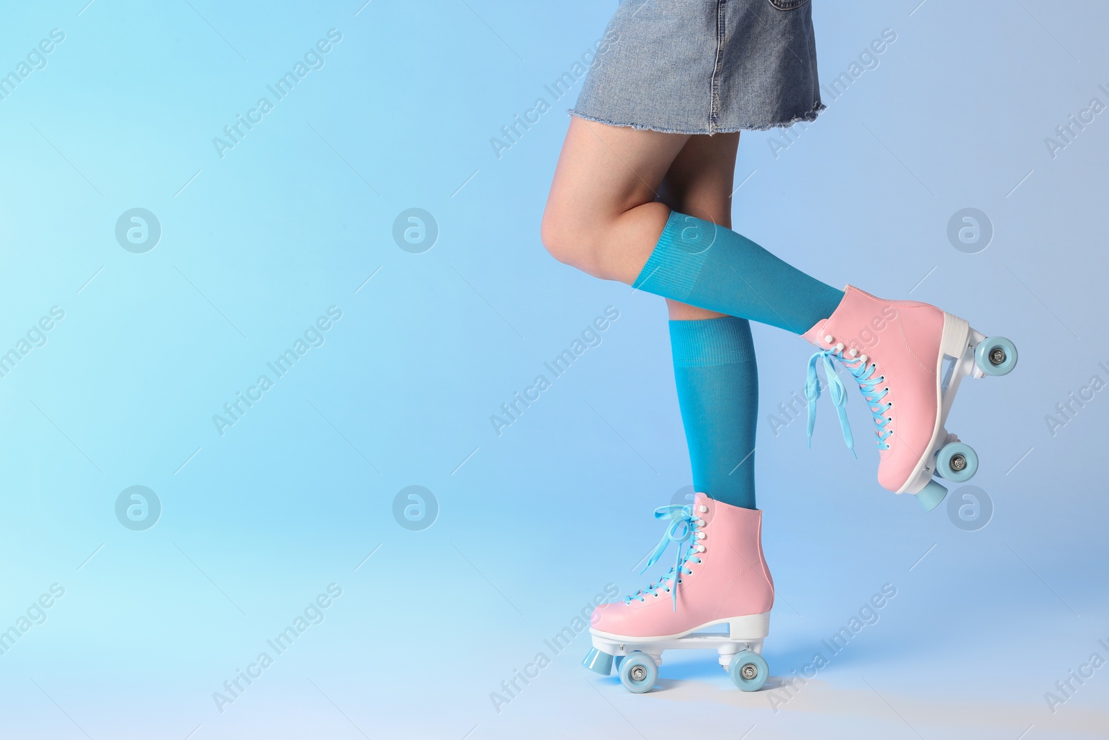 Photo of Woman with vintage roller skates on color background, closeup. Space for text