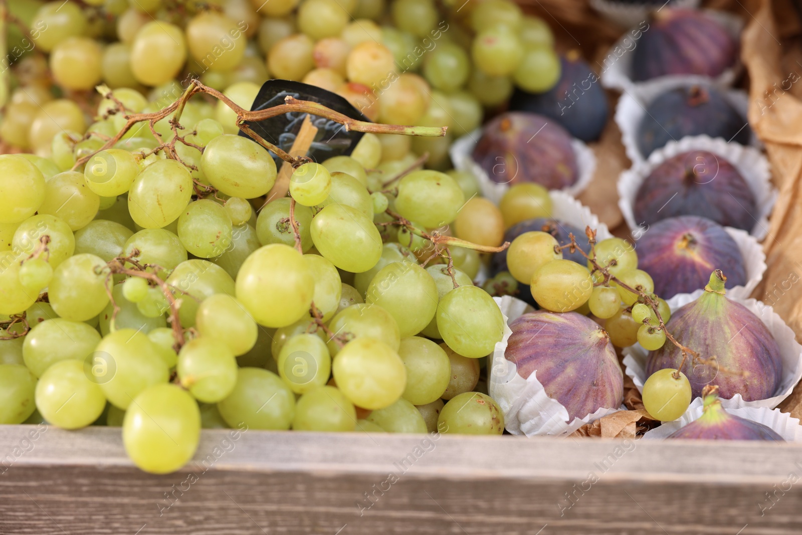 Photo of Fresh ripe fruits in wooden crate at market, closeup