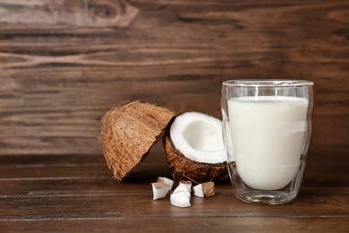 Photo of Glass with coconut milk and fresh nuts on wooden background