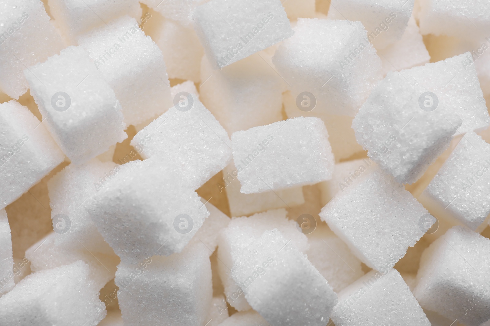 Photo of White refined sugar cubes as background, closeup