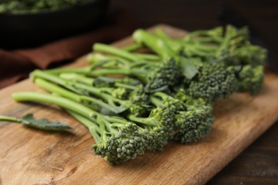 Fresh raw broccolini on wooden board, closeup. Healthy food