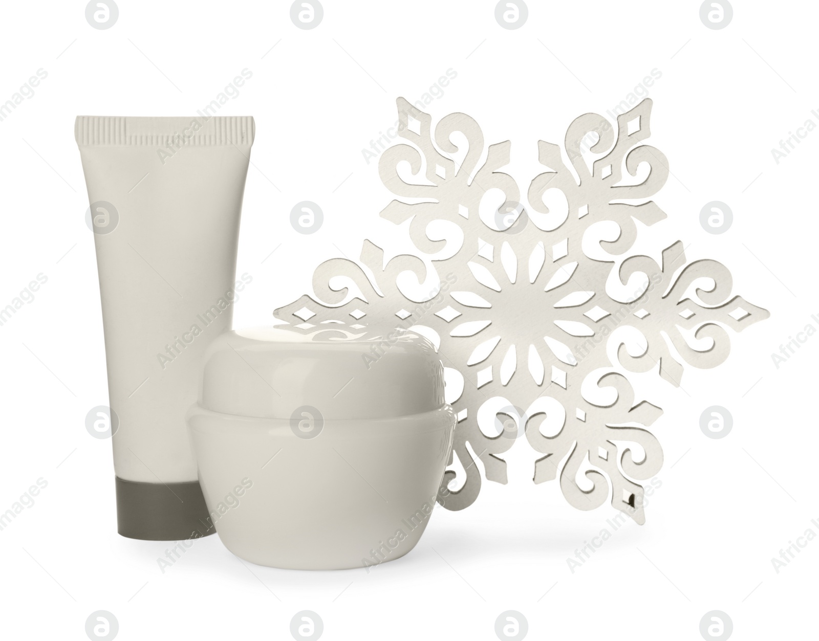 Photo of Cosmetic products and snowflake on white background. Winter skin care