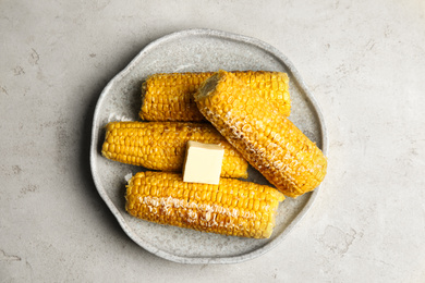 Delicious grilled corn with butter on light grey table, top view
