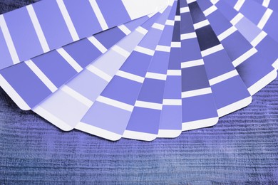 Image of Color palette samples of violet shades on wooden background, closeup