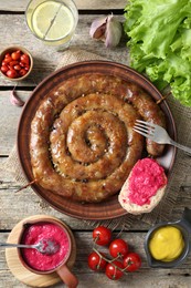 Tasty homemade sausages served on wooden table, flat lay