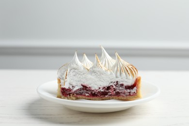 Photo of Tartlet with meringue and jam on white table, closeup. Delicious dessert