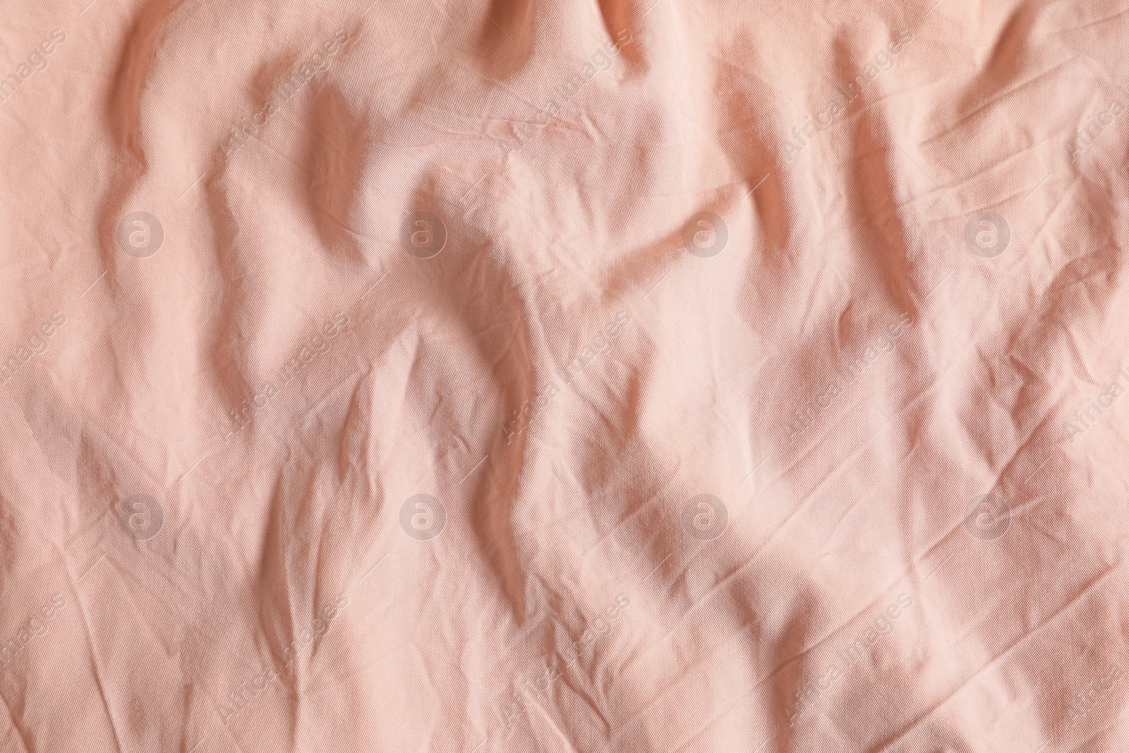 Photo of Crumpled pink fabric as background, top view