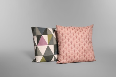 Two stylish decorative pillows on light background