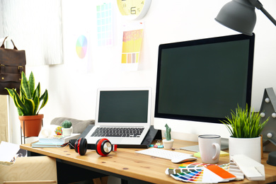 Modern laptop, computer and office supplies on wooden table, space for text. Designer's workplace