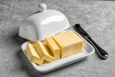 Dish with fresh butter and knife on table