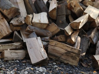 Pile of dry firewood on ground outdoors