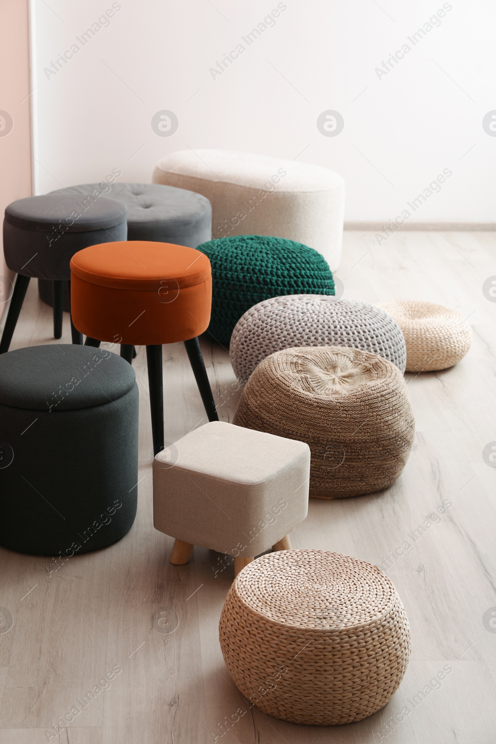 Photo of Different stylish poufs and ottomans in room