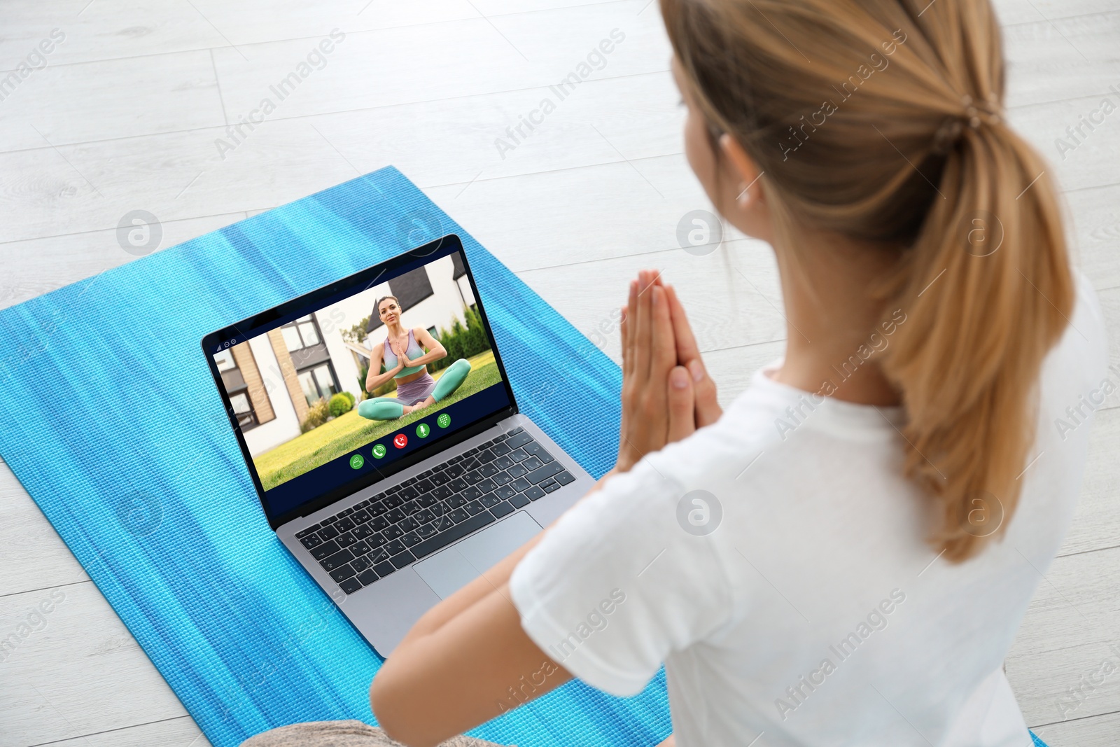 Image of Distance yoga course during coronavirus pandemic. Woman having online practice with trainer via laptop at home