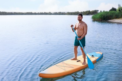 Photo of Man paddle boarding on SUP board in sea, space for text