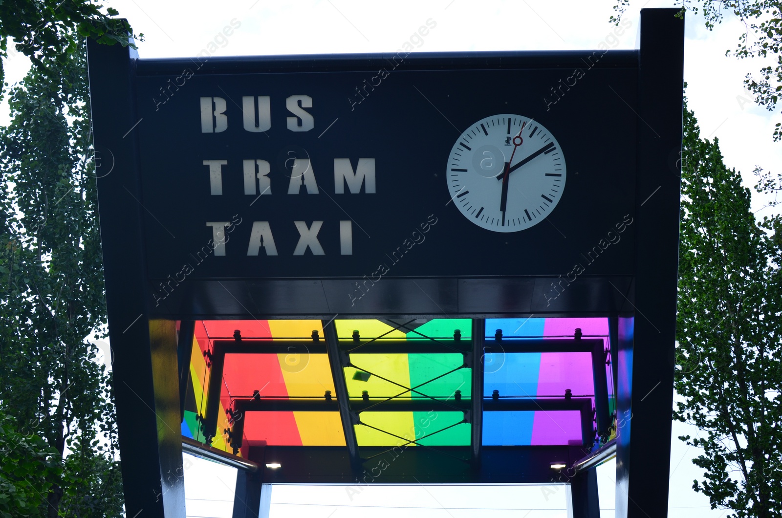 Photo of Bus, taxi and tram station with rainbow flag outdoors