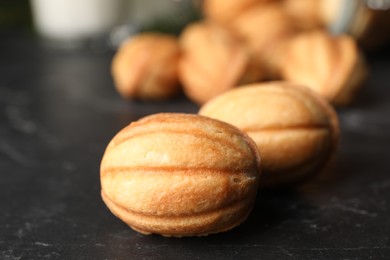 Photo of Homemade walnut shaped cookies on black table, closeup