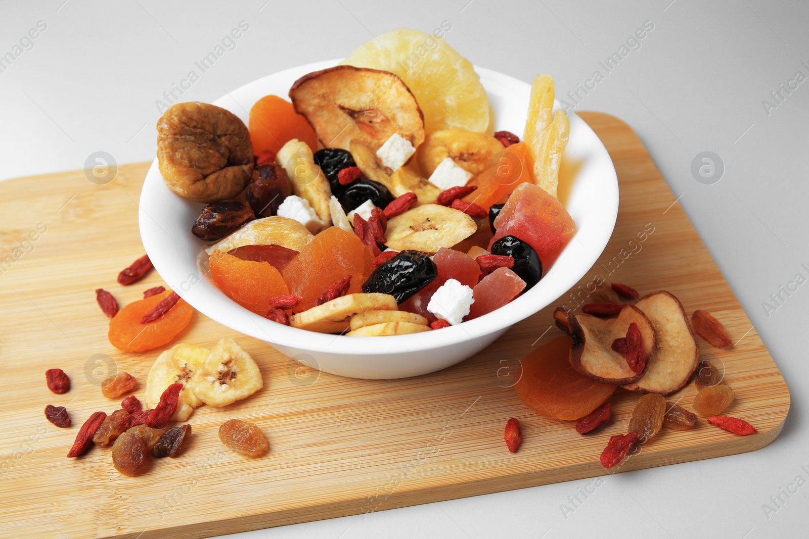 Photo of Bowl with different dried fruits on white background