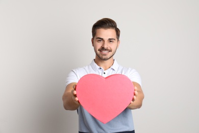 Photo of Portrait of young man with decorative heart on light background