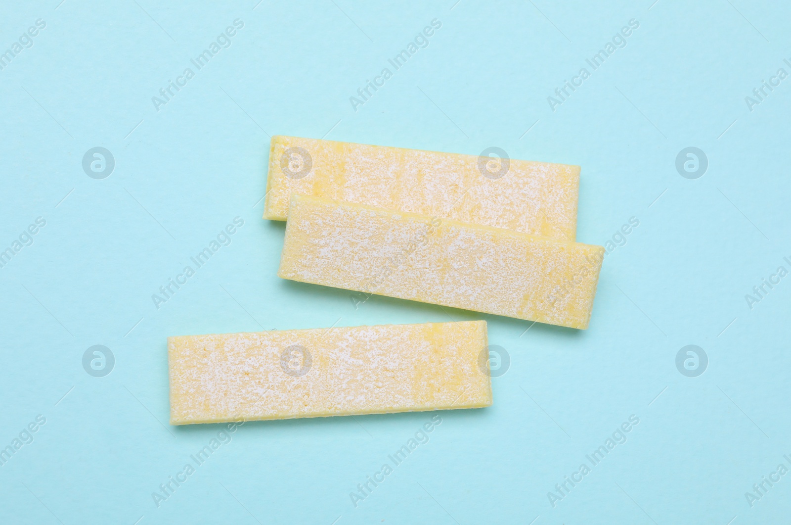 Photo of Sticks of tasty chewing gum on turquoise background, flat lay