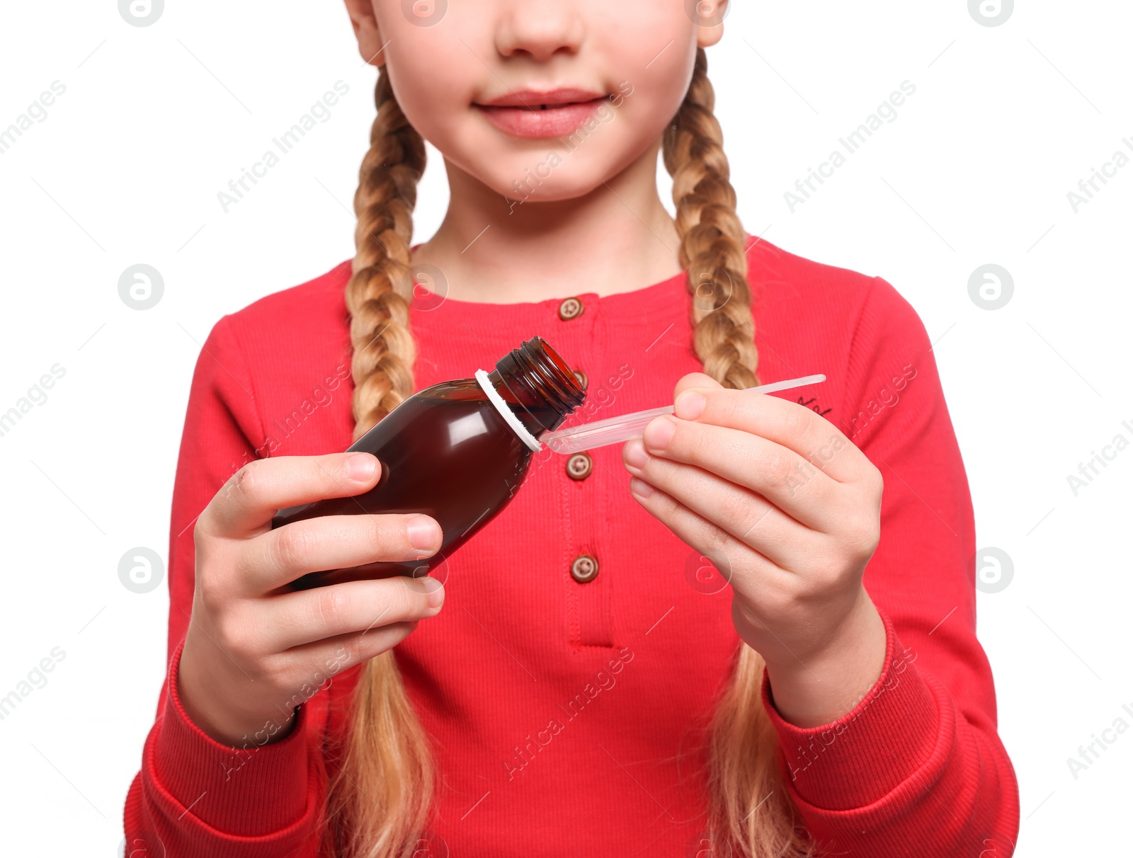 Photo of Cute girl pouring syrup from bottle into dosing spoon on white background, closeup