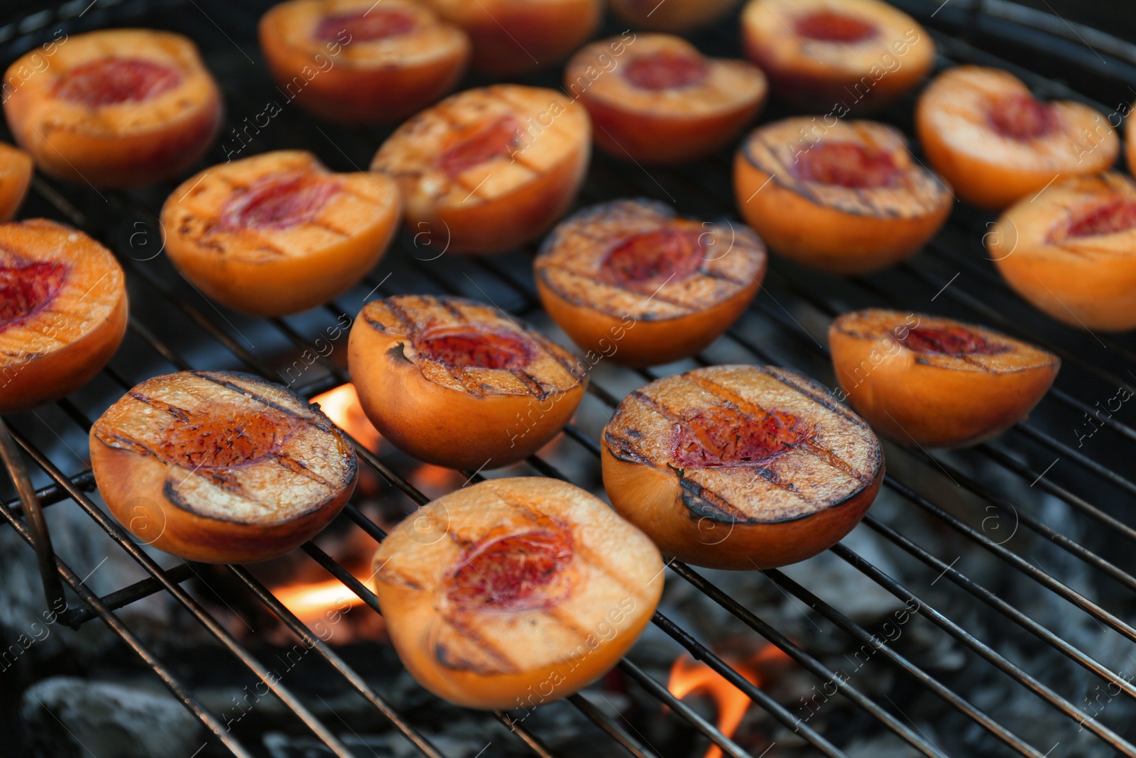 Photo of Modern grill with tasty cut peaches, closeup