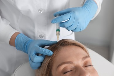 Photo of Trichologist giving injection to patient in clinic, closeup