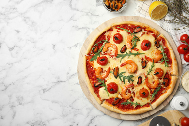 Photo of Delicious seafood pizza on white marble table, flat lay. Space for text