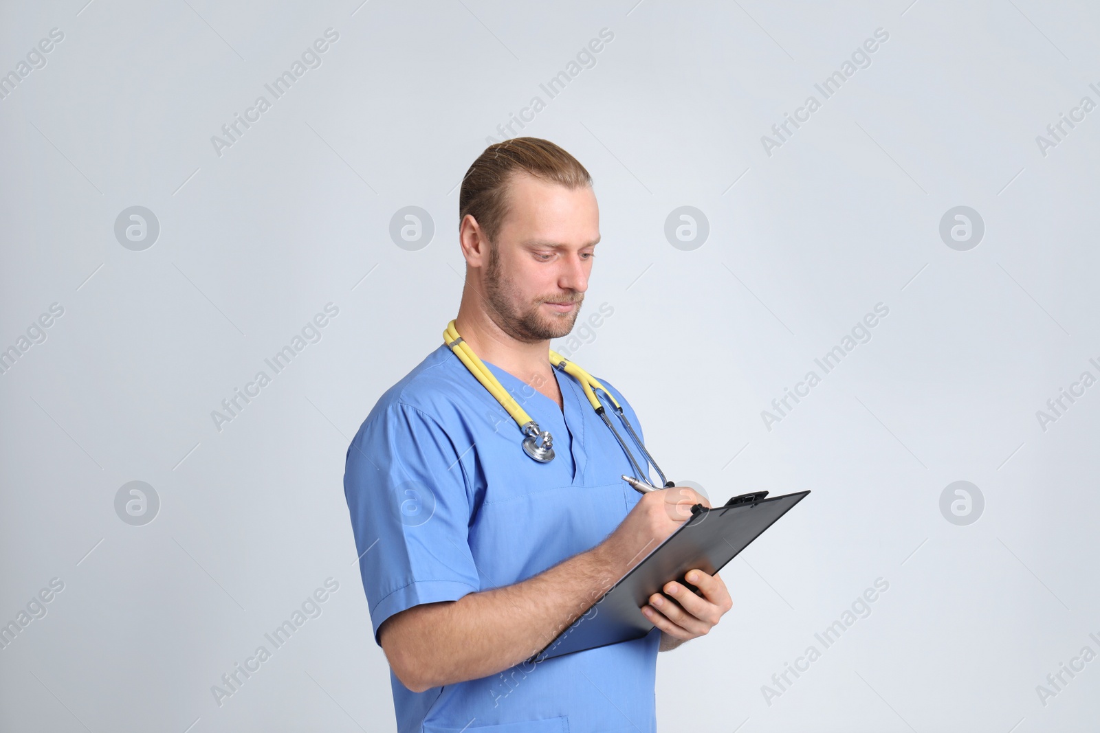 Photo of Portrait of medical assistant with stethoscope and clipboard on color background