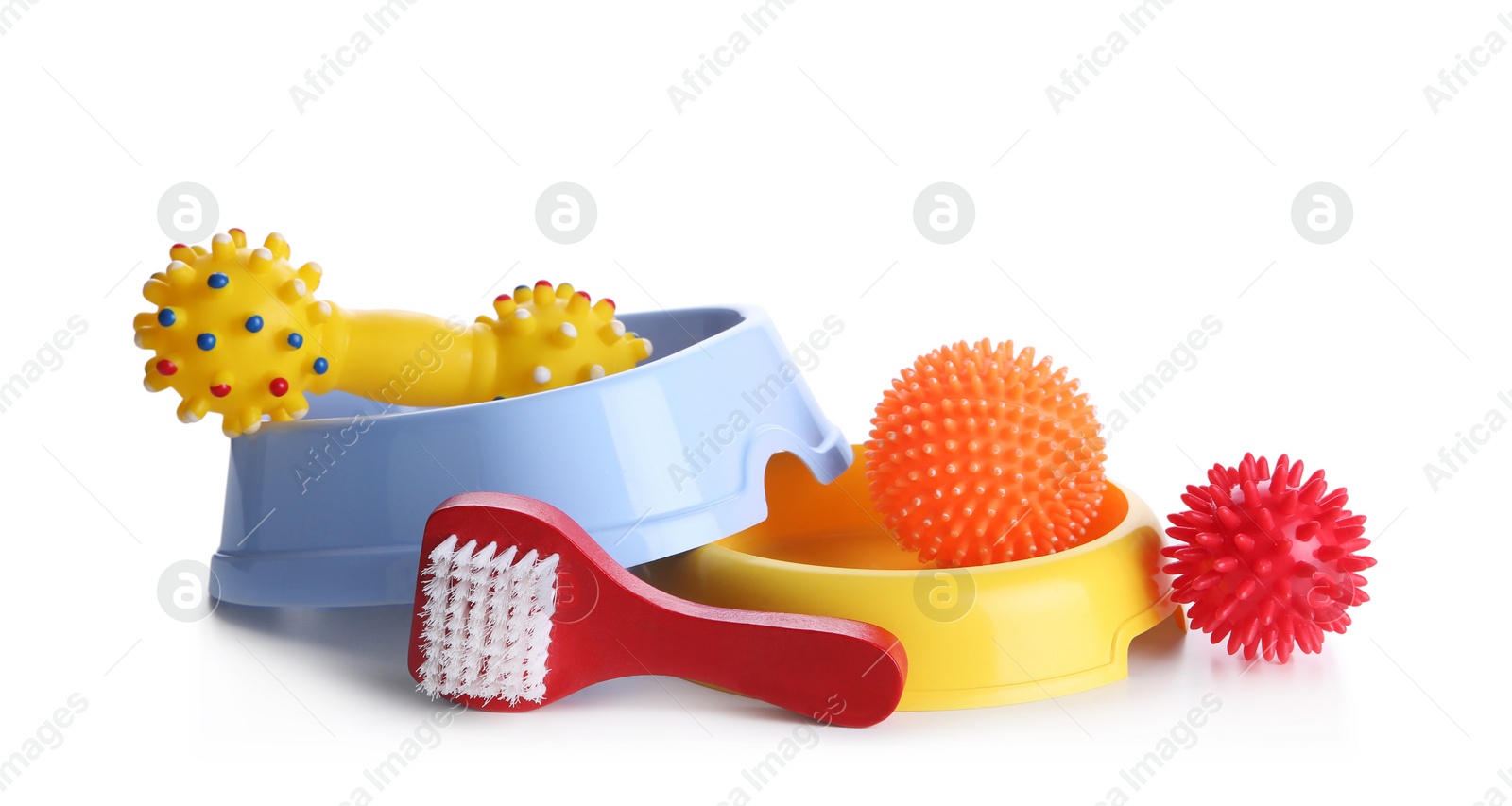 Photo of Feeding bowls, brush and dog toys on white background