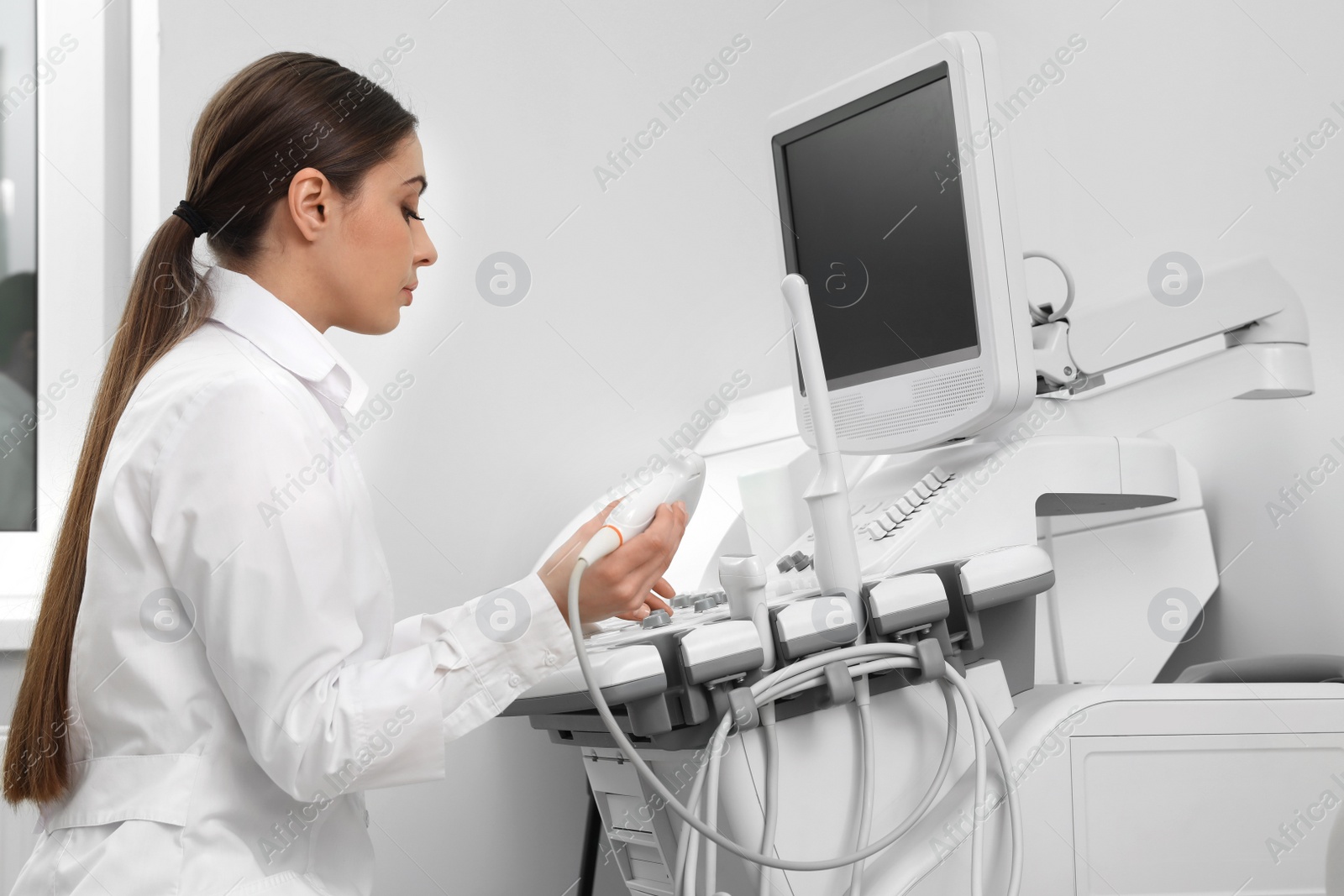 Photo of Professional sonographer using modern ultrasound machine in clinic