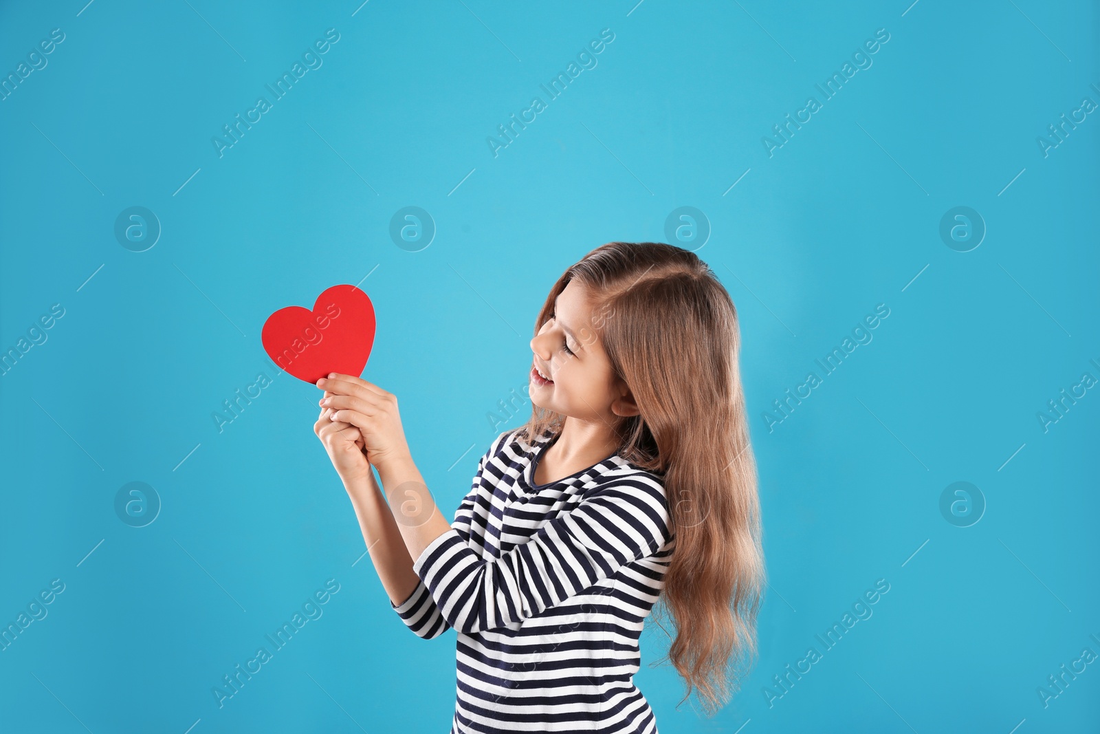 Photo of Portrait of girl with paper heart on color background