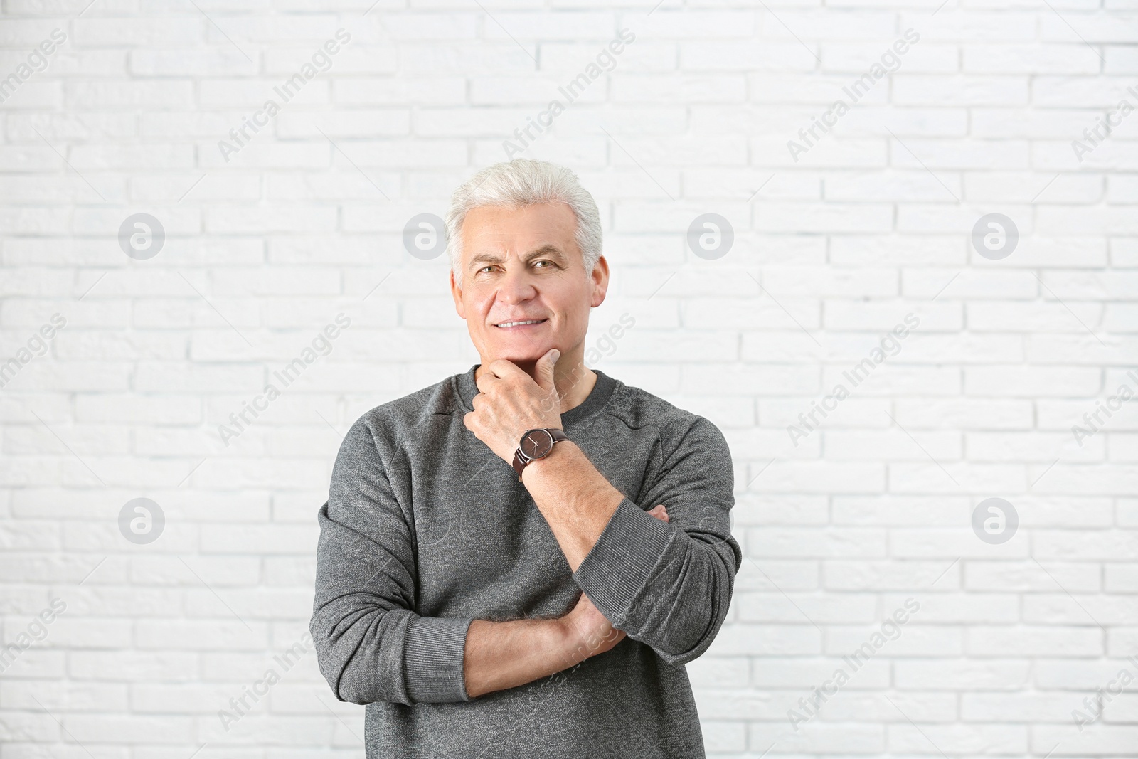 Photo of Portrait of handsome mature man near brick wall