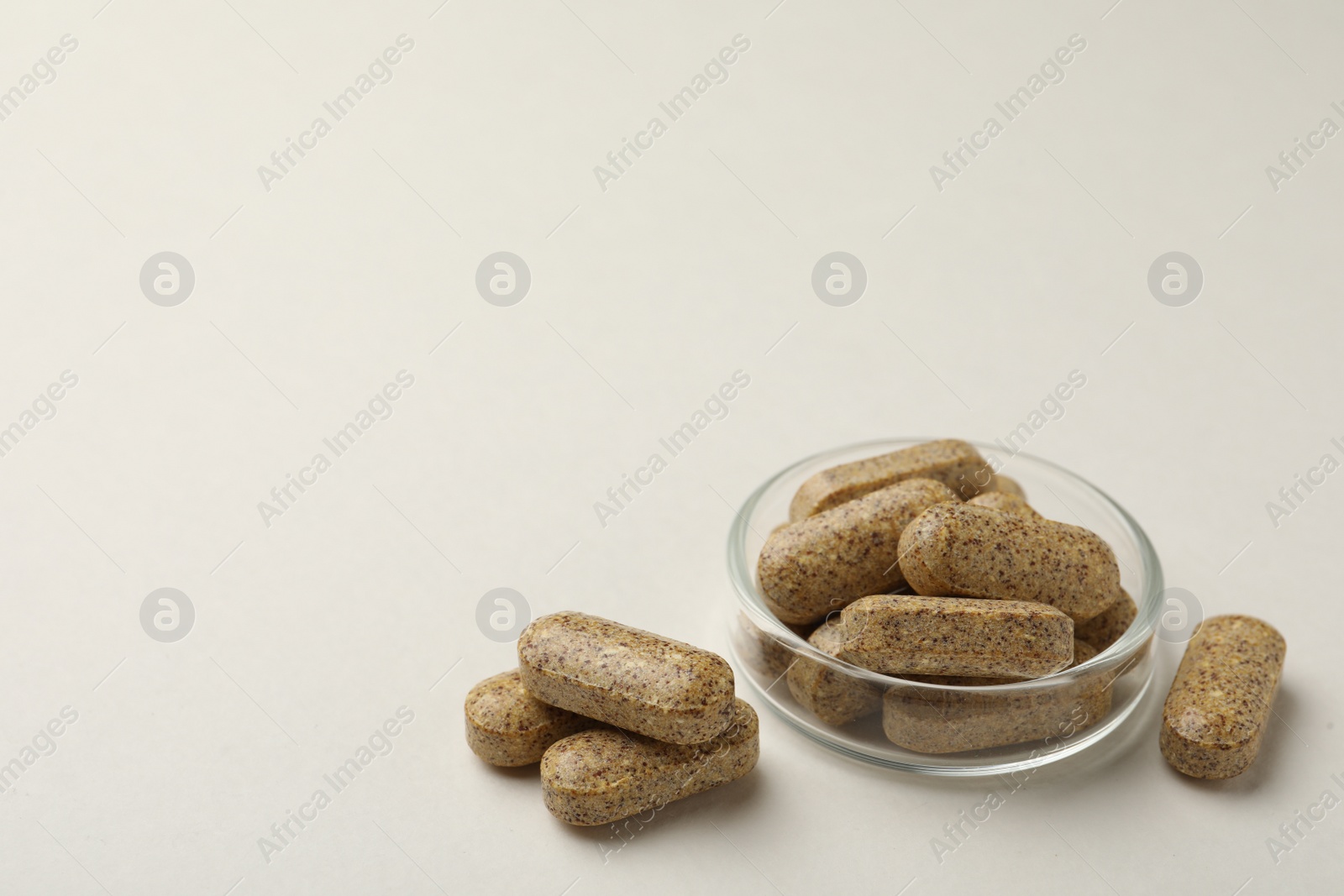 Photo of Dietary supplement pills on white background. Space for text