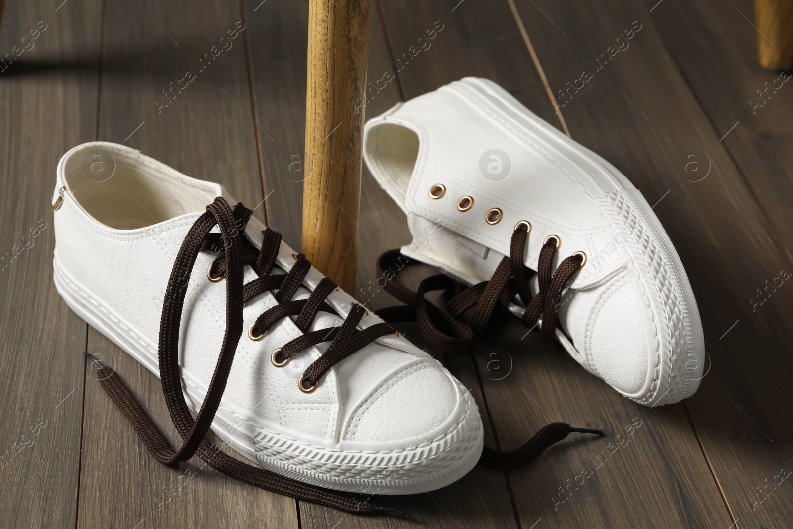 Photo of Pair of stylish shoes with brown laces on wooden floor indoors