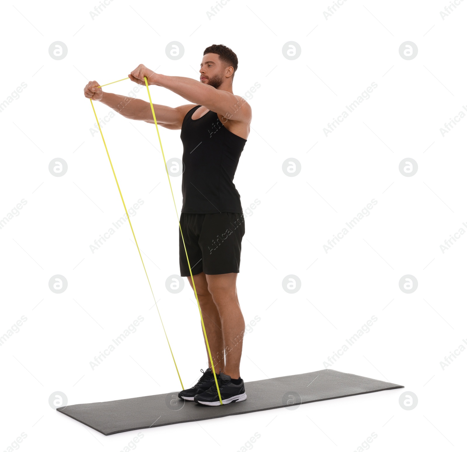 Photo of Young man exercising with elastic resistance band on fitness mat against white background