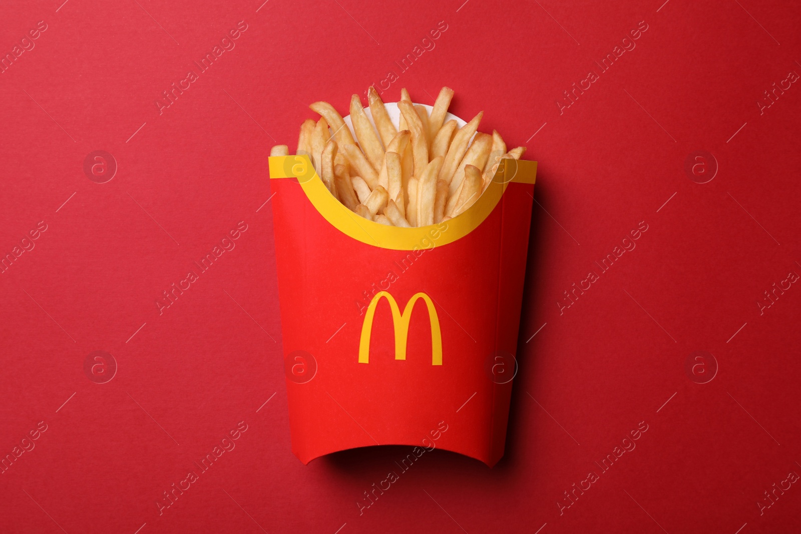 Photo of MYKOLAIV, UKRAINE - AUGUST 12, 2021: Big portion of McDonald's French fries on red background, top view