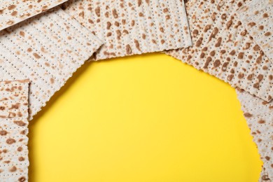 Photo of Traditional matzos on yellow background, flat lay. Space for text