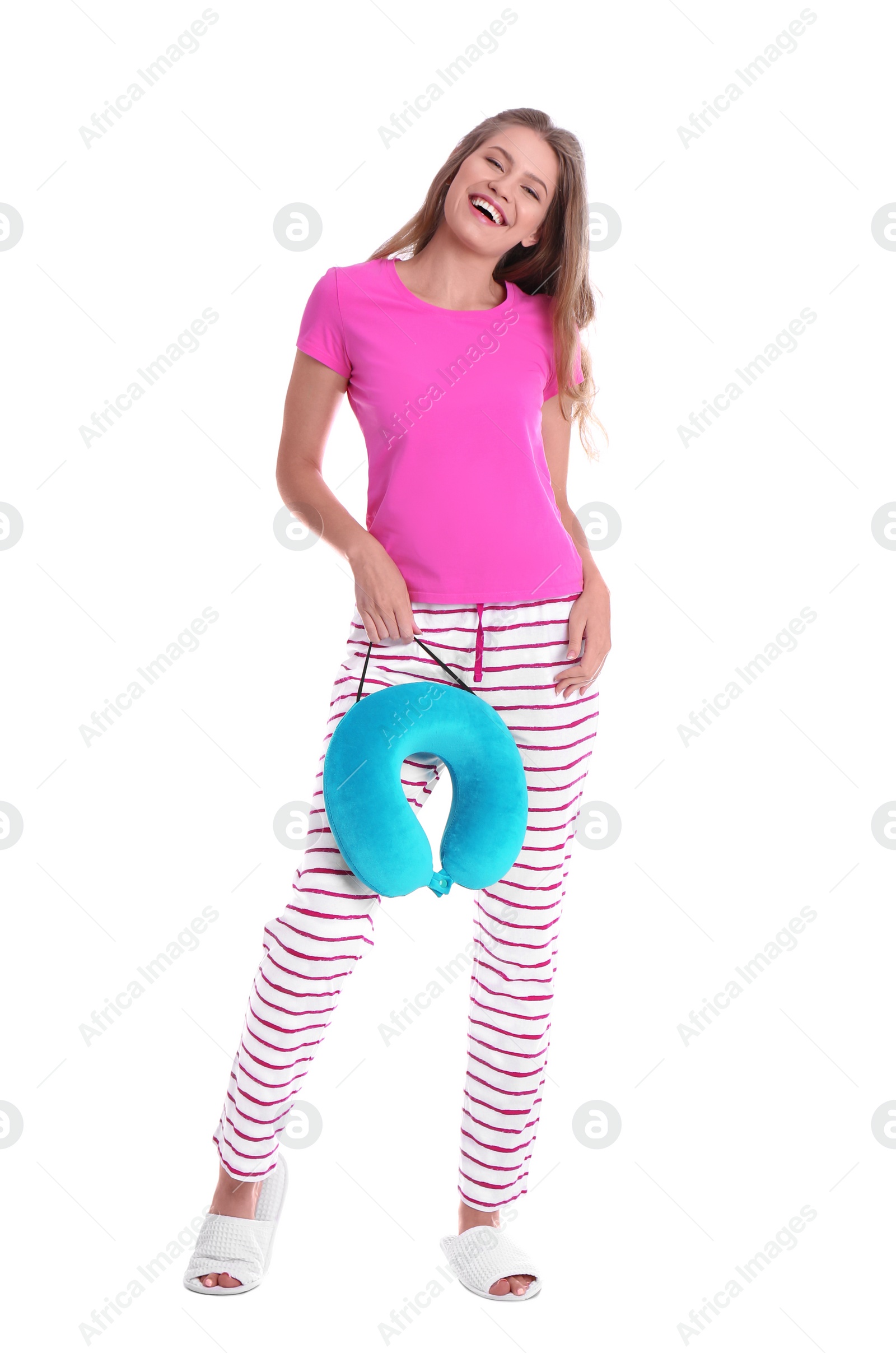 Photo of Happy young woman in pajamas with neck pillow on white background
