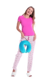 Happy young woman in pajamas with neck pillow on white background