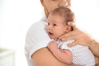 Photo of Man with his newborn baby on light background