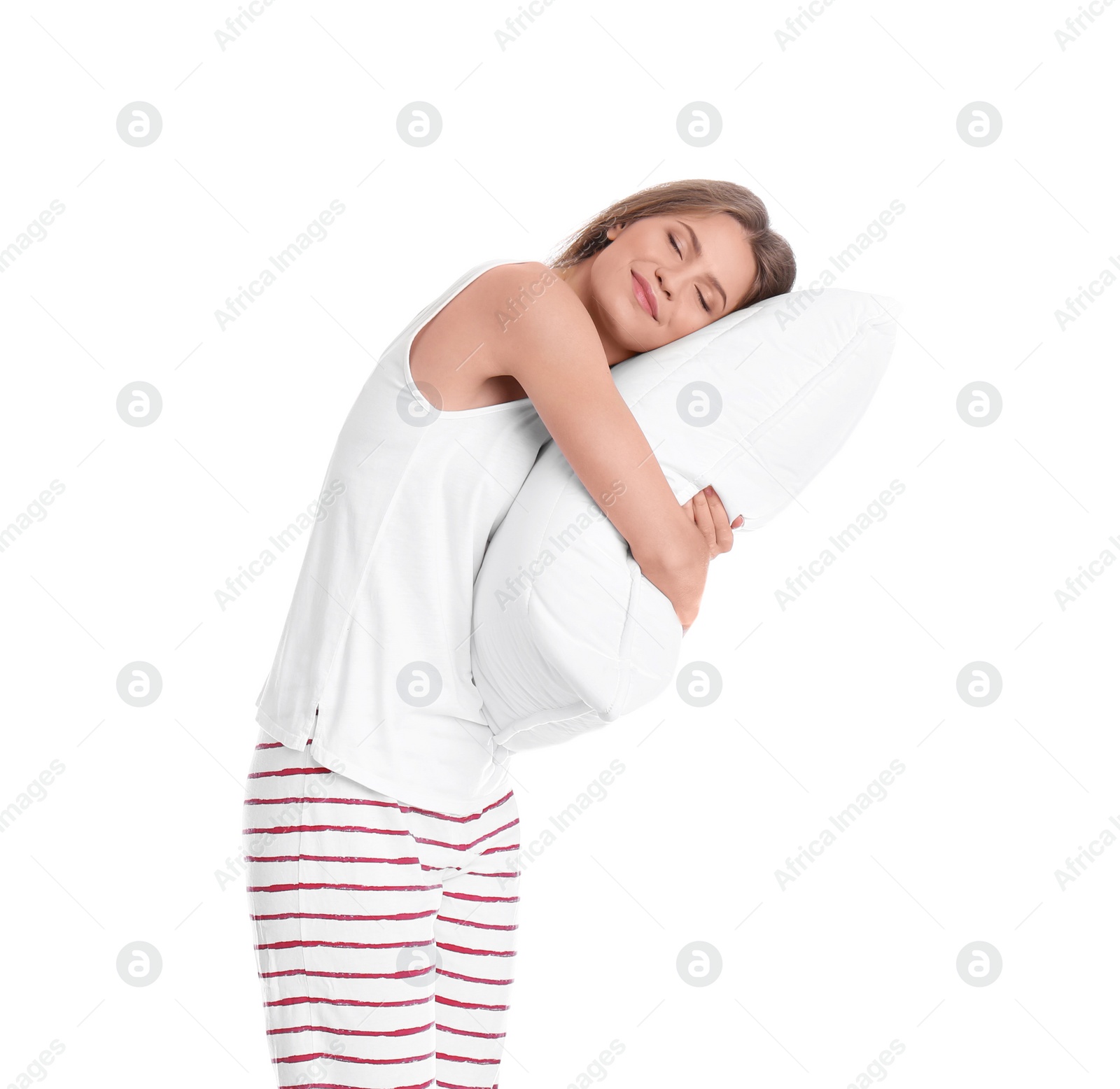 Photo of Young woman in pajamas embracing pillow on white background