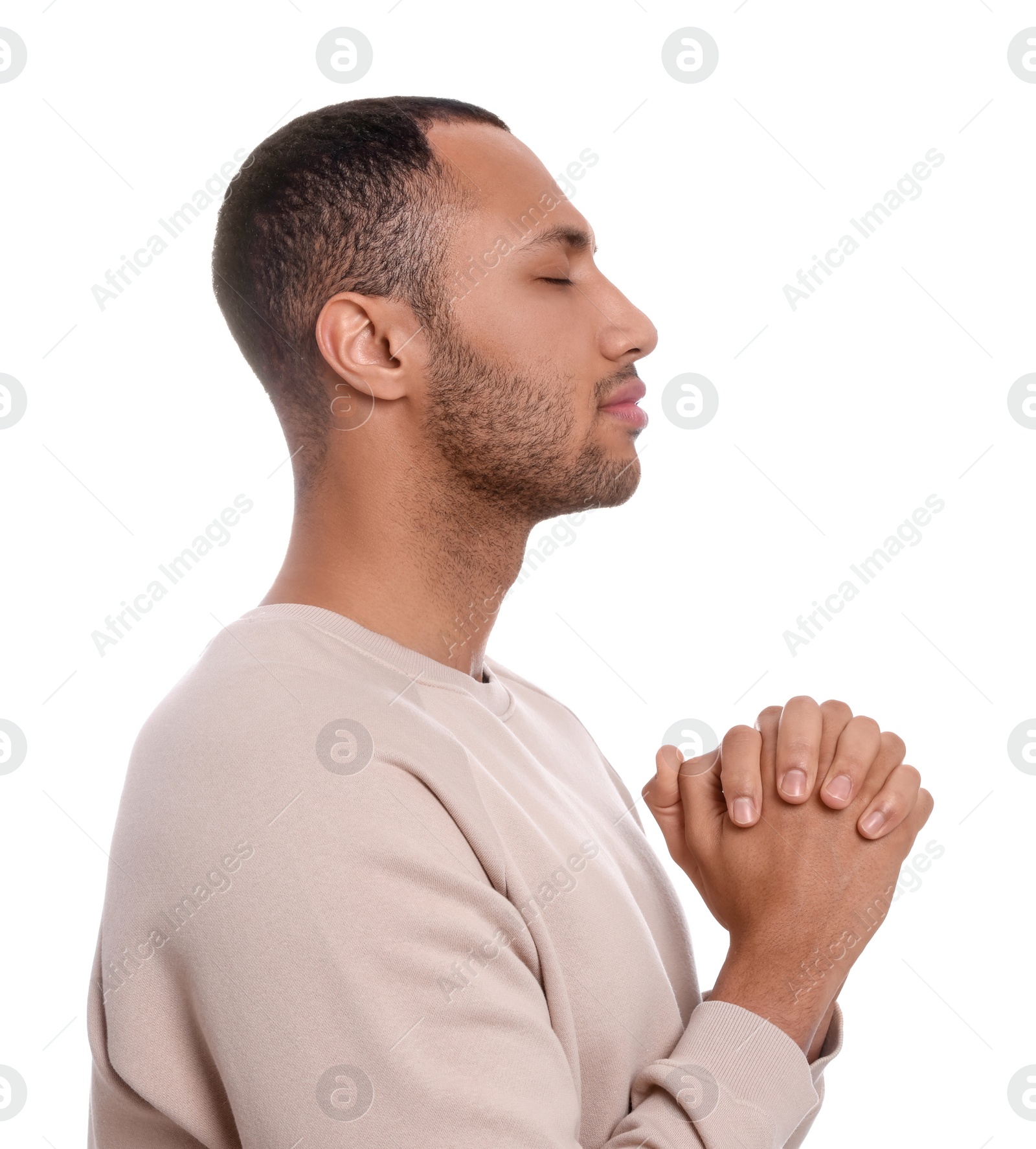 Photo of African American man with clasped hands praying to God on white background