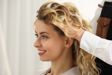 Hair styling. Professional hairdresser working with smiling client indoors, closeup