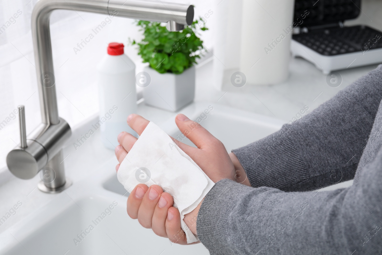 Photo of Man wiping hands with paper towel near sink, closeup